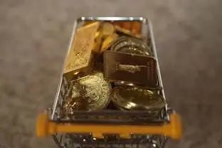 physical gold coins and gold bars filling a shopping cart to represent investors buying gold