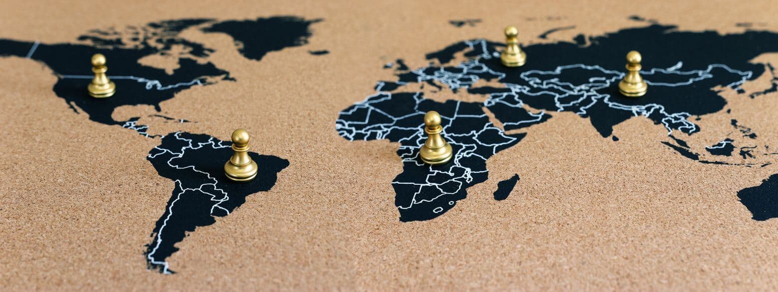 a world map with golden chess pieces on top a world map with golden chess pieces on top