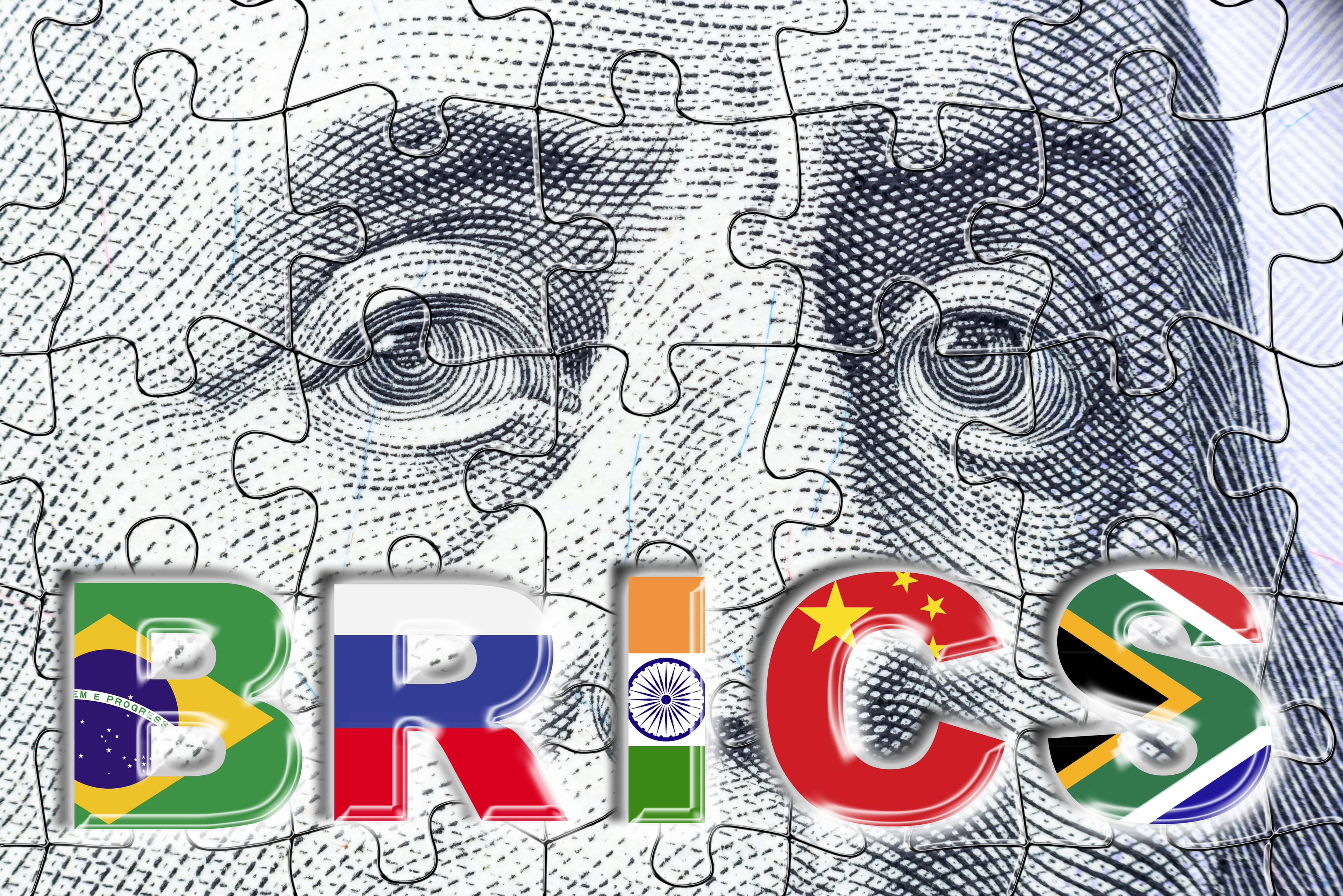 Die neue BRICS-Währung: Welche Rolle spielt sie für den Dollar und den Goldpreis? Ein Puzzle, bestehend aus dem US-Dollar mit den Buchstaben „B“, „R“, „I“, „C“, „S“.