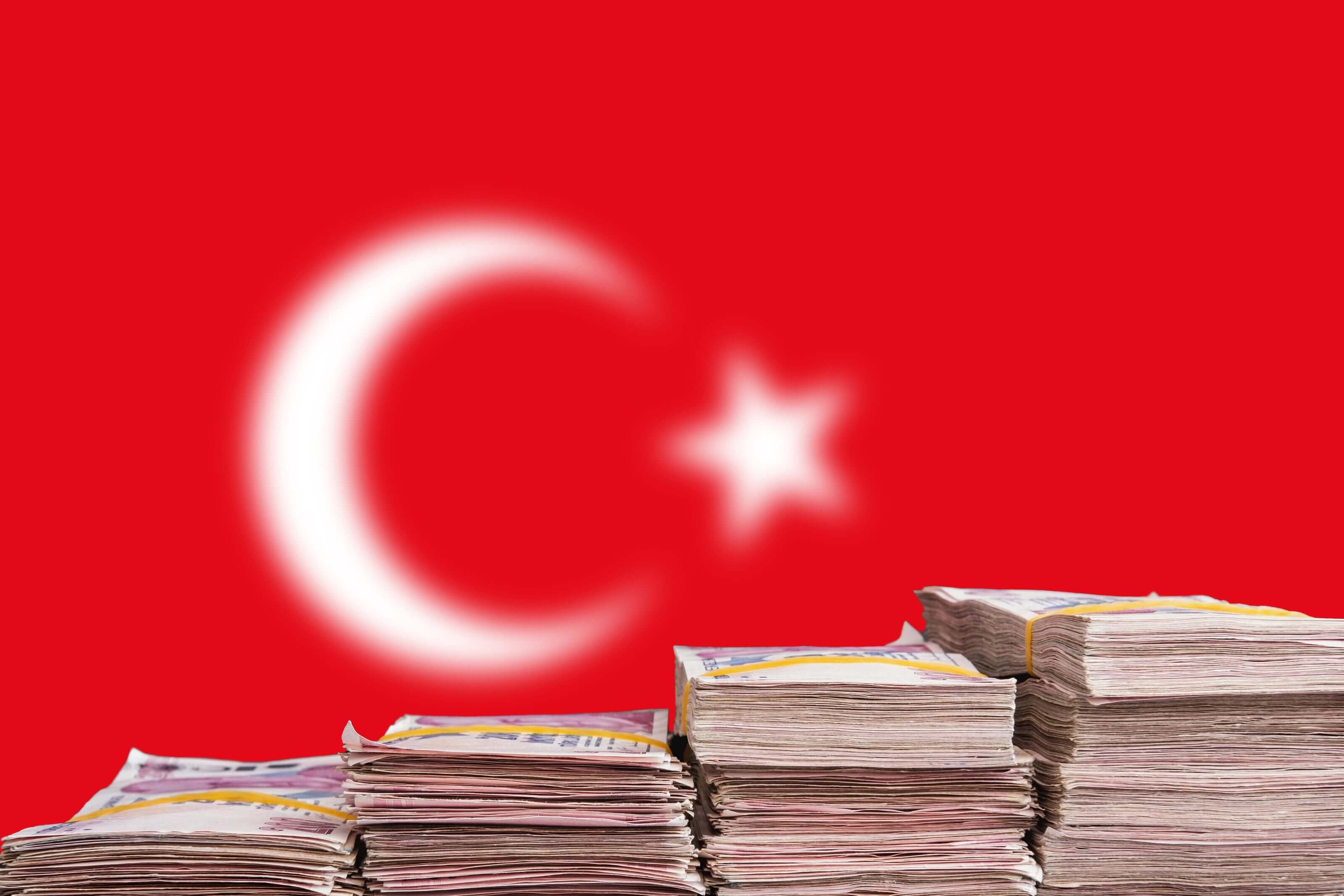 What Inflation Feels Like in Real Life: the Case of Turkey  the Turkish lira notes after a historic 15% crash stacked in front of the Turkish flag