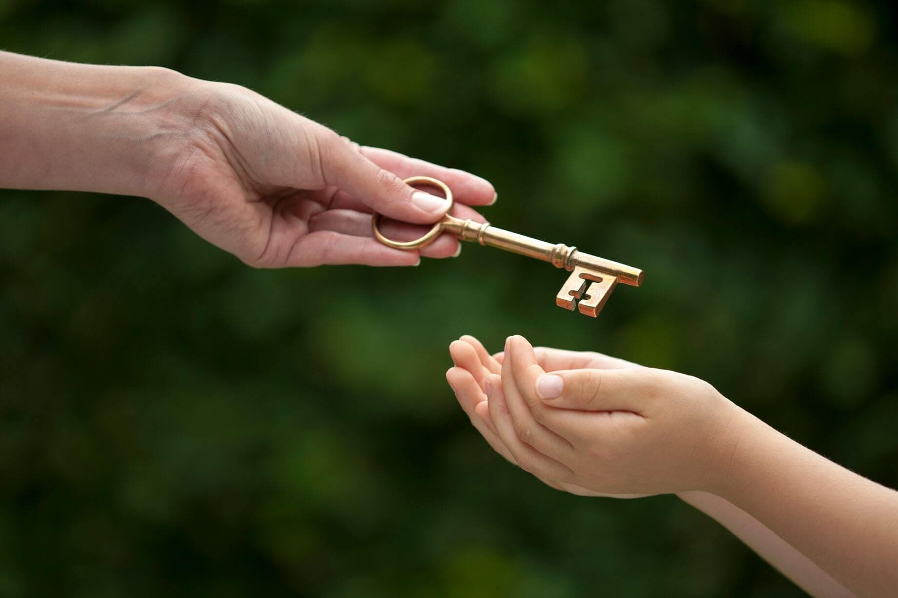 3 Ways Gold Savings Can Benefit Your Children and Family parents starting to save for their kid’s future as early as possible to build them a reliable safety net represented by a picture of an adult passing a golden key on to a child